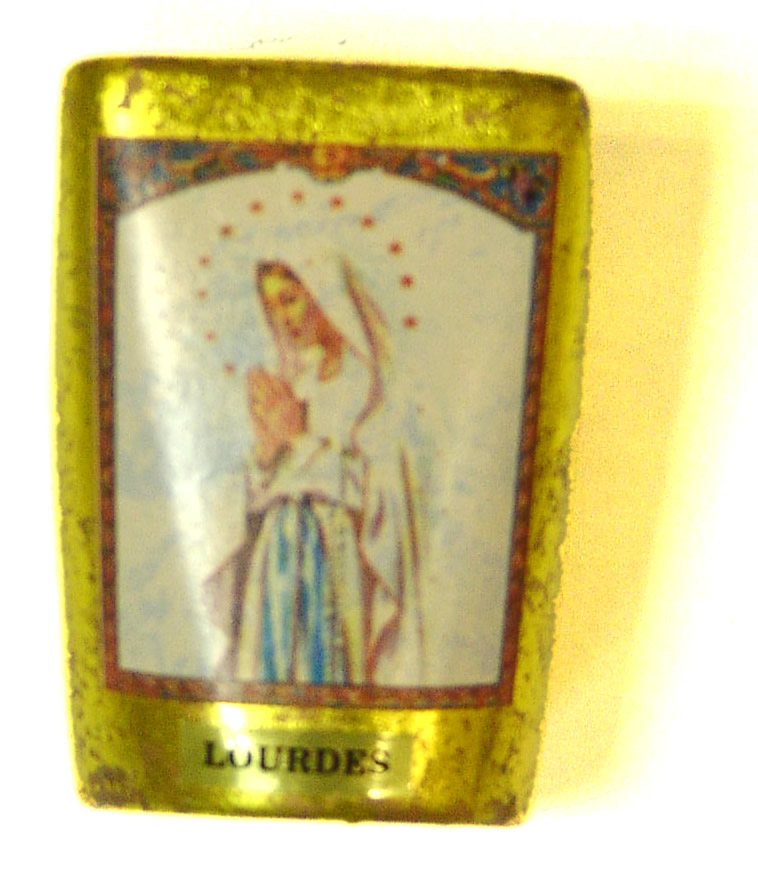 Golded candle with image of Sainte Bernadette praying